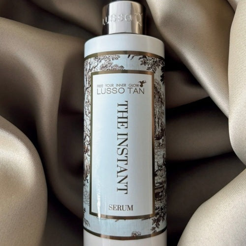 Lusso Tan The Instant Tan Serum bottle on a beige fabric background