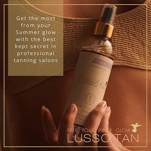 Bottle of Lusso Tan primer held by a hand with promotional text.