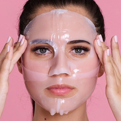 Woman wearing a Skin Republic Collagen Hydrogel sheet face mask against a pink background