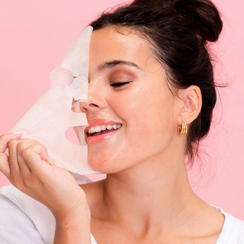 Woman applying a Skin Republic Retinol skincare product with a pink background