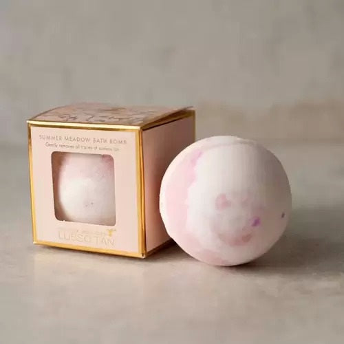 Lusso Tan Removing bath bomb with a gold box on a neutral background